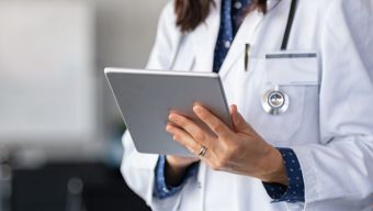 Ärztin oder Arzt mit Tablet und Stethoskop – Symbol für digitales Forderungsmanagement in der Medizin / Physician with a tablet and stethoscope, symbolizing digital receivables management in healthcare